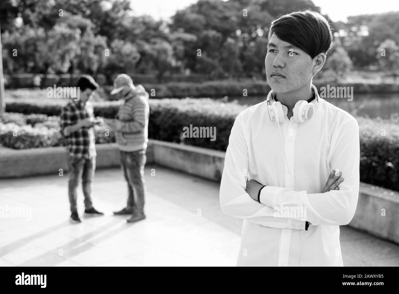 Tre giovani uomini asiatici di relax presso il parco insieme Foto Stock