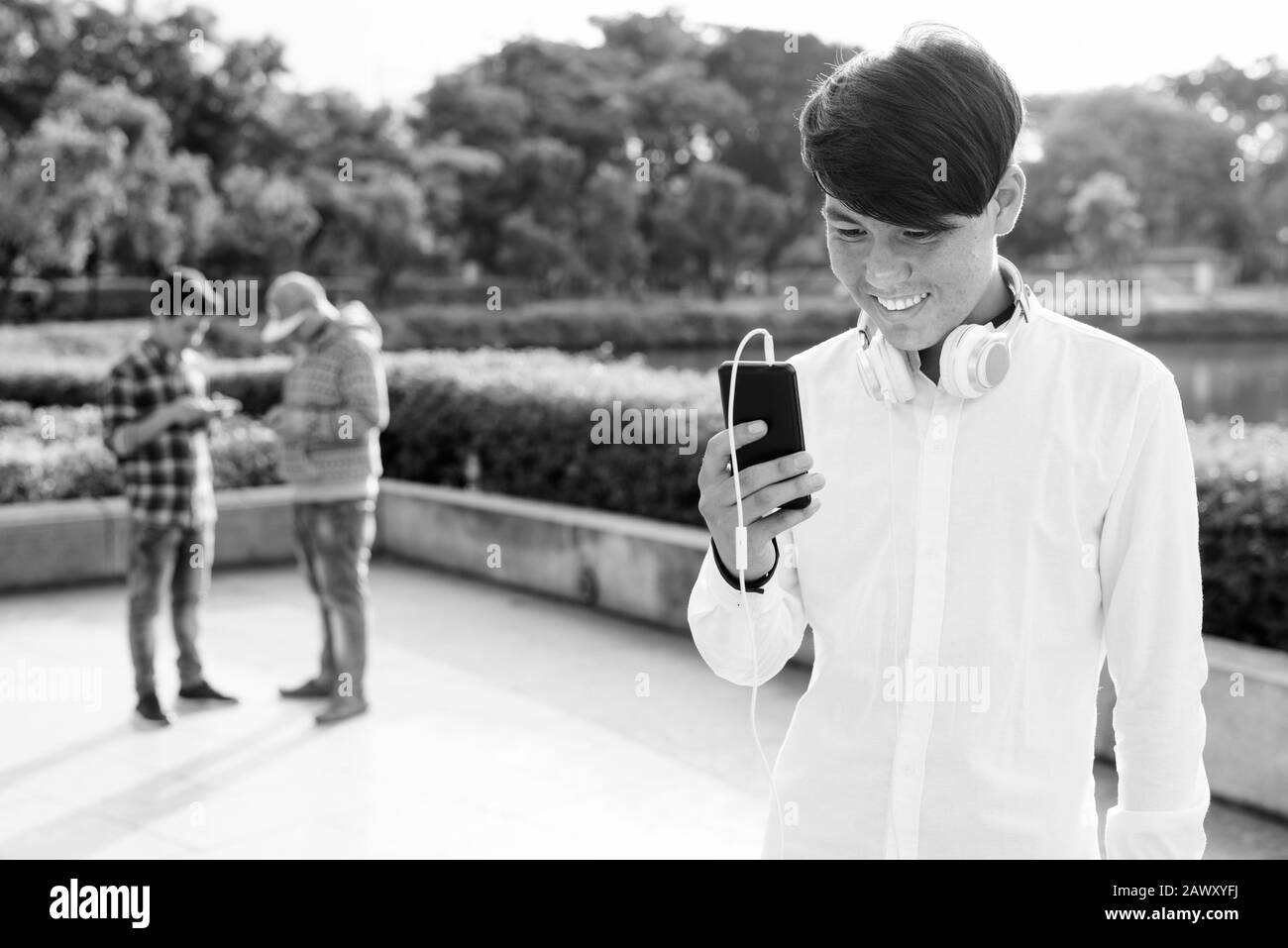 Tre giovani uomini asiatici di relax presso il parco insieme Foto Stock