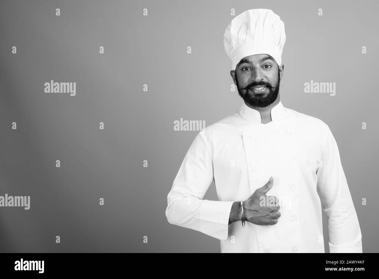 Ritratto di giovane bell'uomo indiano bearded come chef Foto Stock