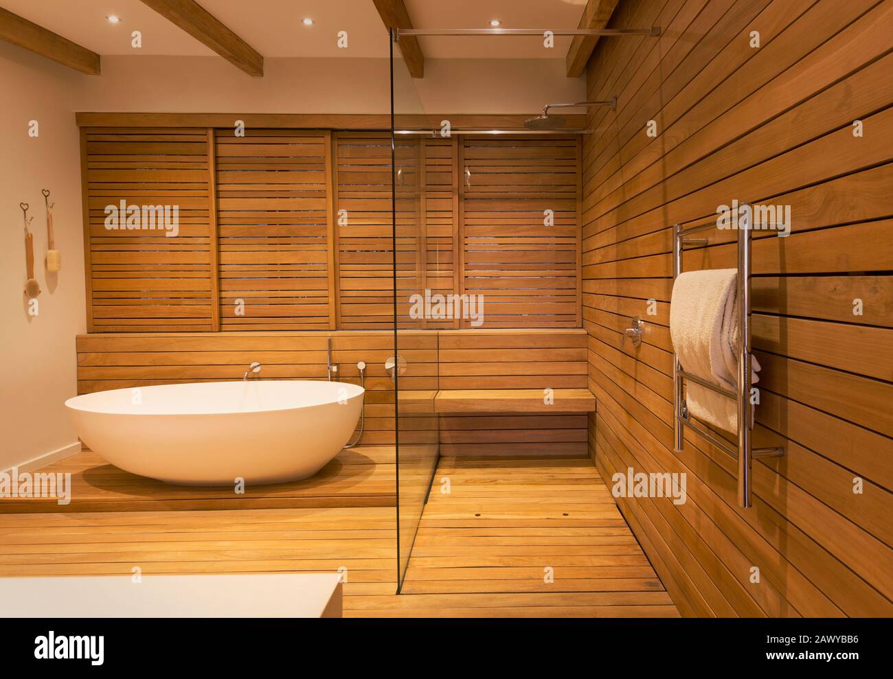 Vasca e doccia circondate da pareti in legno in un moderno e lussuoso bagno interno con vetrina Foto Stock