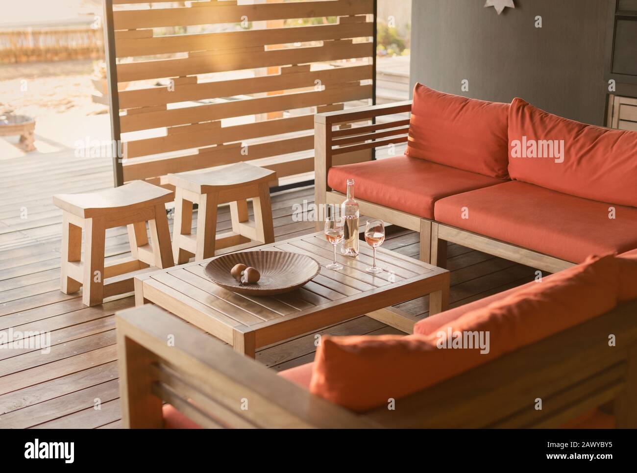 Vino di rose e divano su un patio in legno, moderno e di lusso Foto Stock