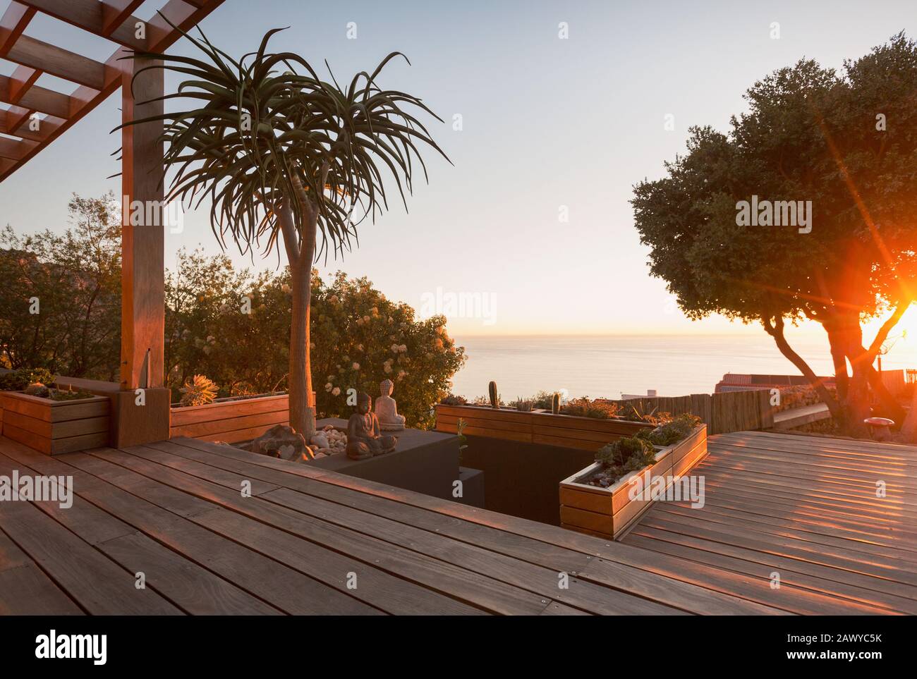 Tranquilla e moderna casa di lusso mostra esterno ponte in legno con vista oceano tramonto Foto Stock