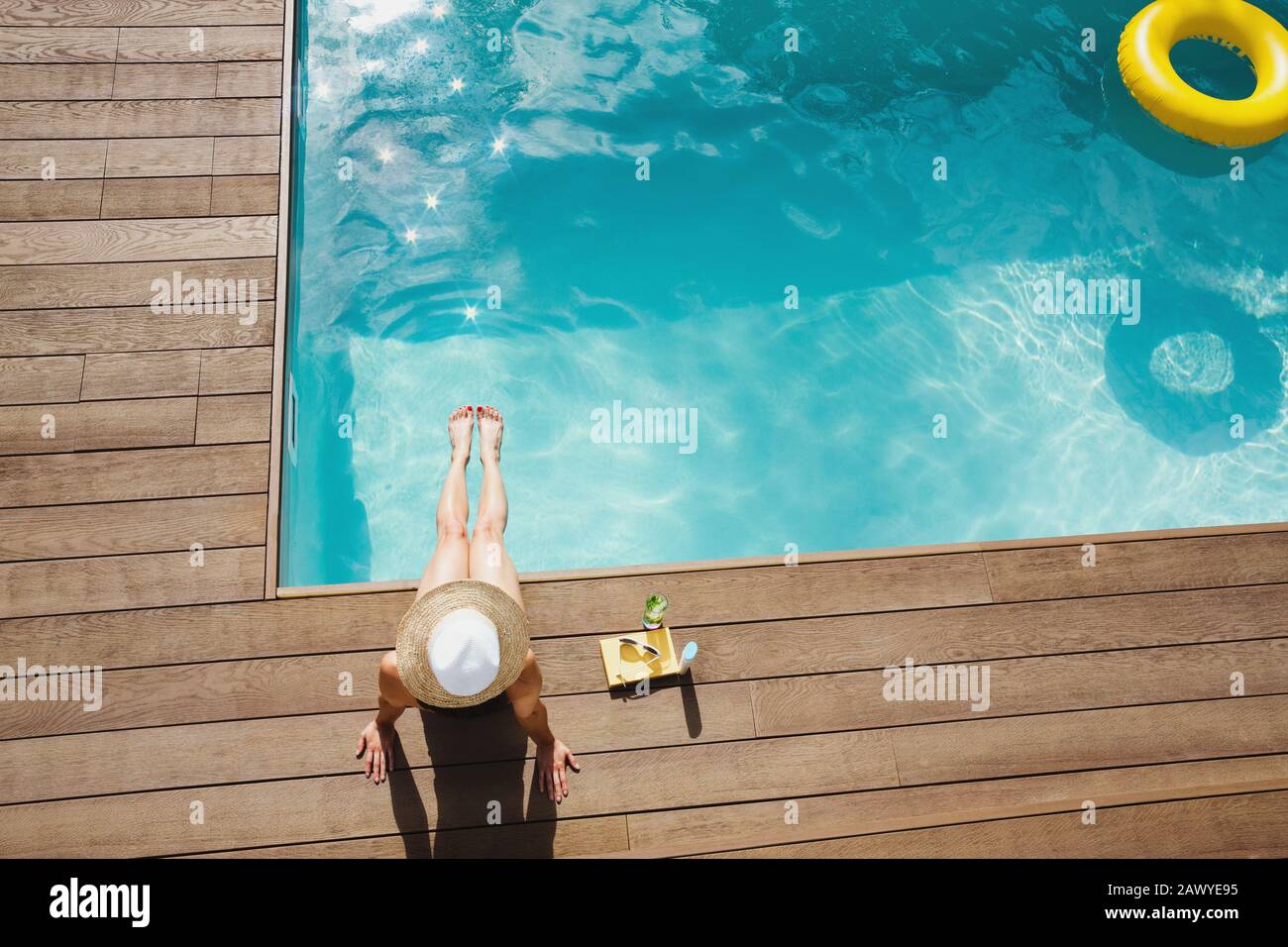 Donna al sole in cappello rilassante, prendere il sole a bordo piscina estate Foto Stock
