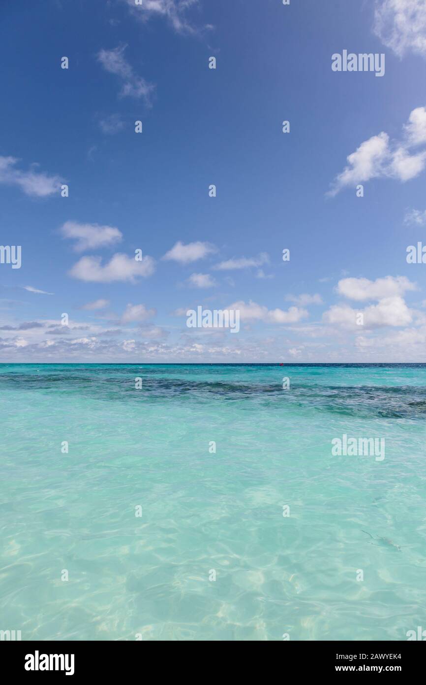 Idilliaco oceano turchese sotto cielo blu soleggiato, Maldive Foto Stock