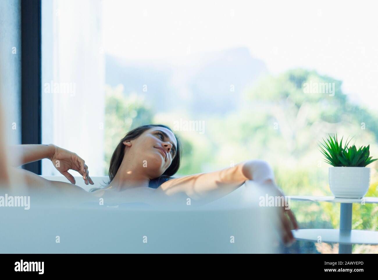 Donna serena rilassante in vasca da bagno Foto Stock