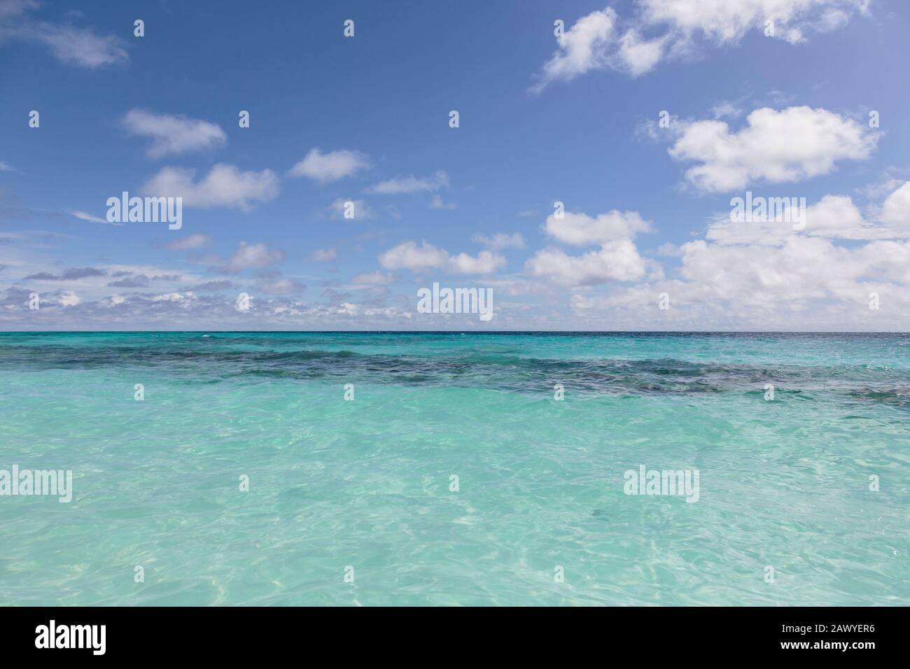 Tranquillo oceano turchese sotto cielo blu sole, Maldive Foto Stock