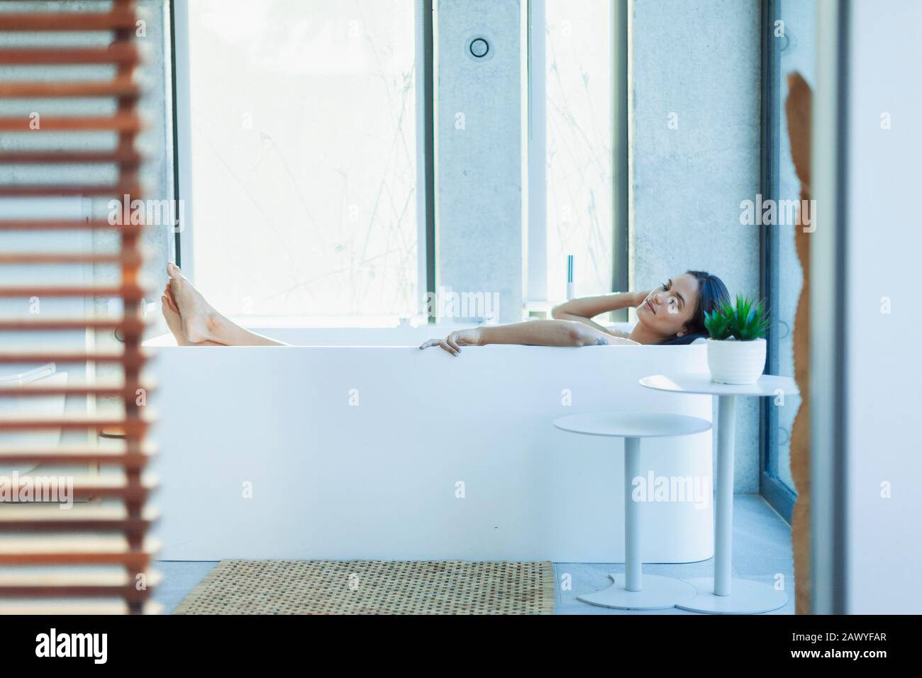 Donna serena rilassante in una moderna vasca da bagno Foto Stock