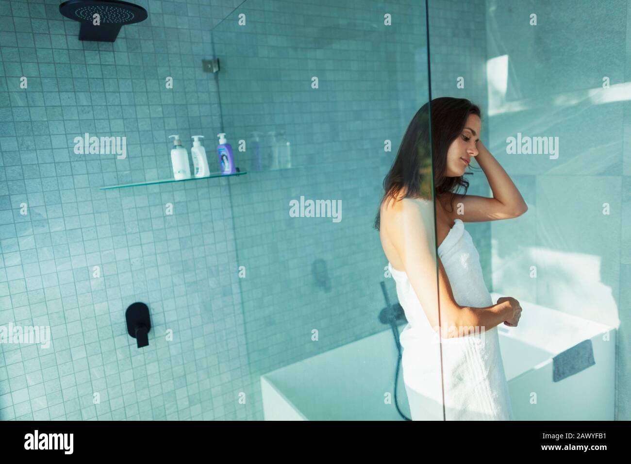 Donna avvolta in un asciugamano nella doccia moderna Foto Stock