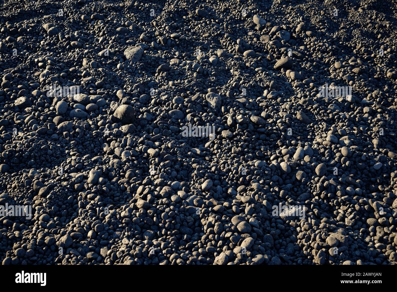 Ciottoli di roccia vulcanica su una spiaggia. Adatto per uno sfondo. Foto Stock