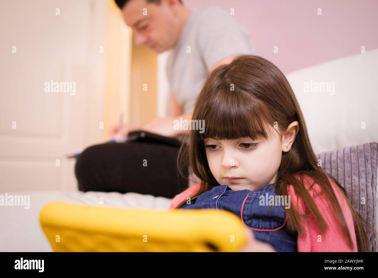 Focalizzato ragazza utilizzando digitale compressa sul divano Foto Stock