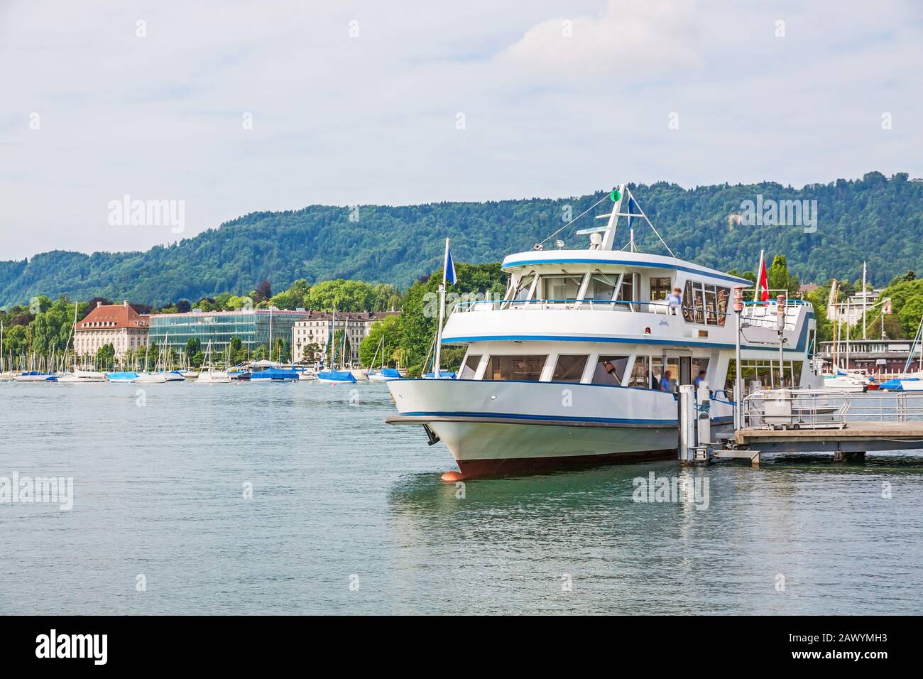 Zurigo, Svizzera - 10 giugno 2017: Imbarcazione per escursioni con arrivo al molo di navigazione Burkliplatz. Riva occidentale del lago di Zurigo, Mythenquai / Enge in backgroun Foto Stock