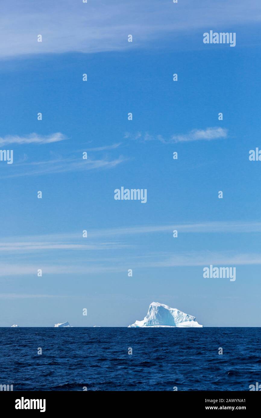 Iceberg in lontananza sul soleggiato blu Oceano Atlantico Groenlandia Foto Stock