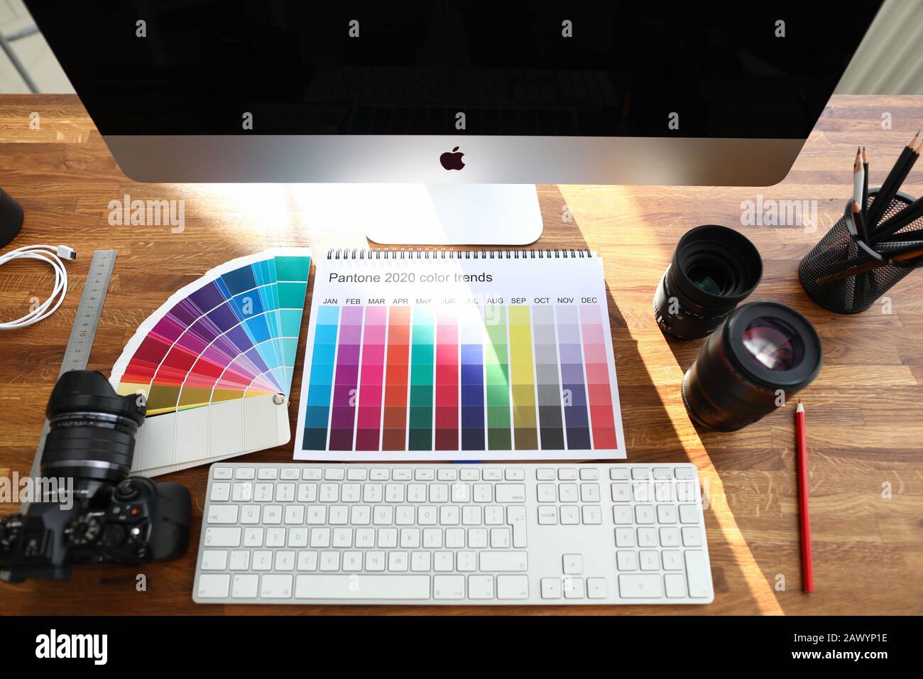 Libro di calendario a colori con le tendenze del colore segno sul tavolo di legno del progettista Foto Stock