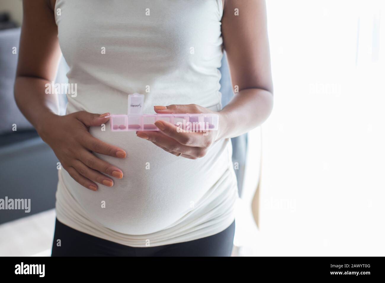 Primo piano donna incinta con scatola di pillola che prende le vitamine Foto Stock