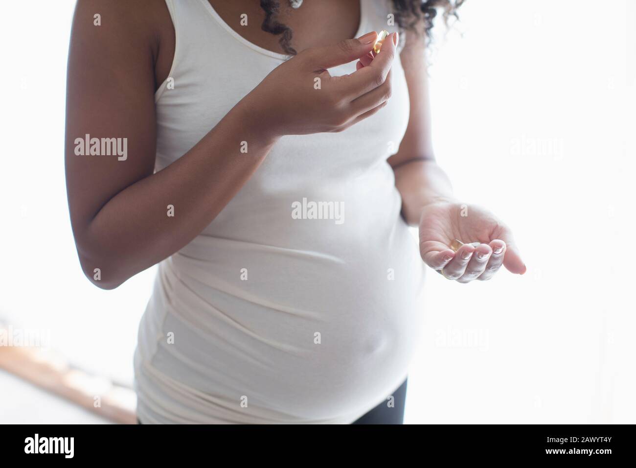 Primo piano su donna giovane incinta che prende le vitamine prenatali Foto Stock