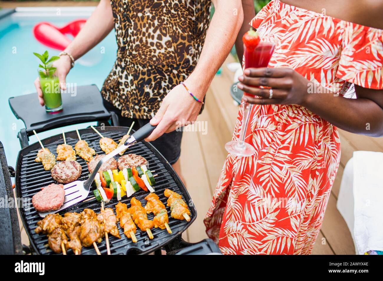 Giovane coppia bevendo cocktail e barbecue Foto Stock