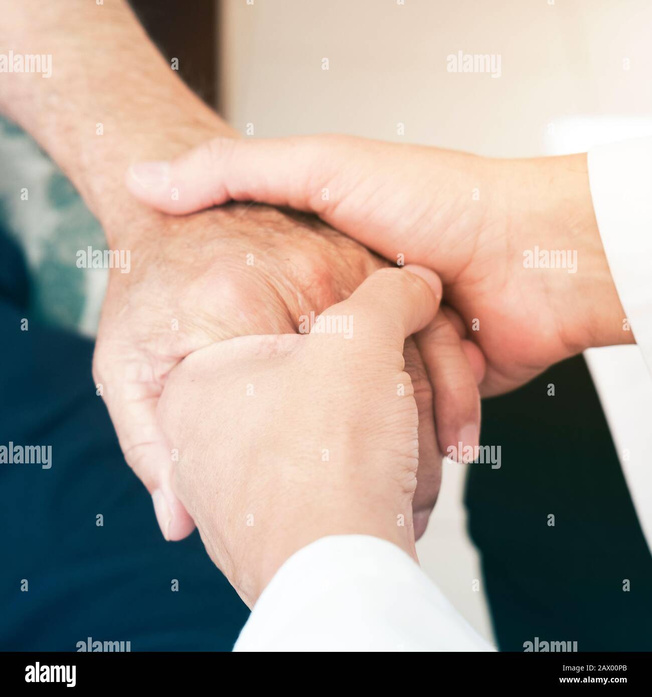 primo piano di un uomo caucasico, in una mano bianca, prendendo la mano di un uomo di pazienti caucasici anziani, a casa sua o in una casa di cura Foto Stock