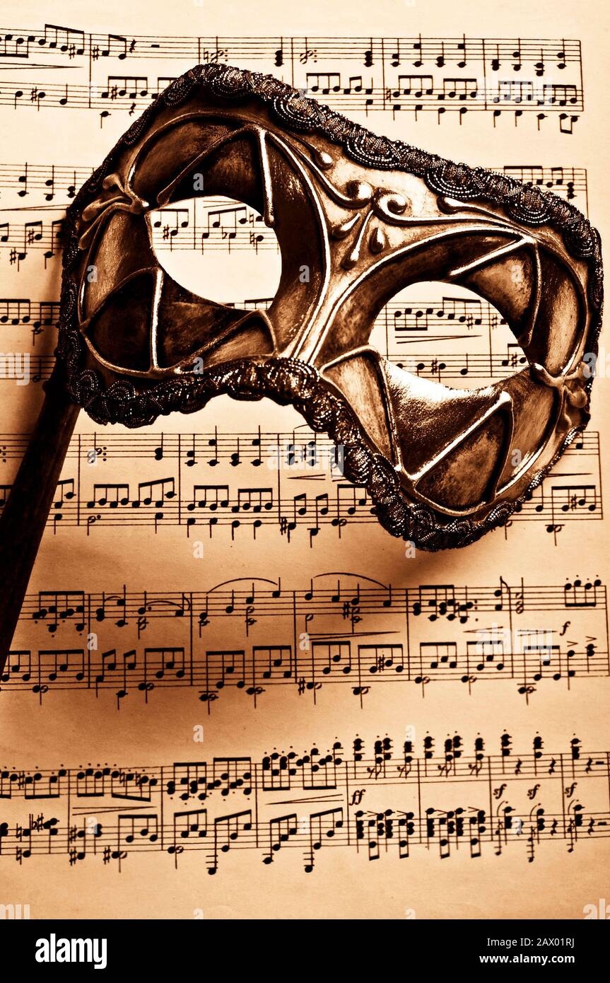 Maschera di carnevale veneziano e musica a segno Foto Stock