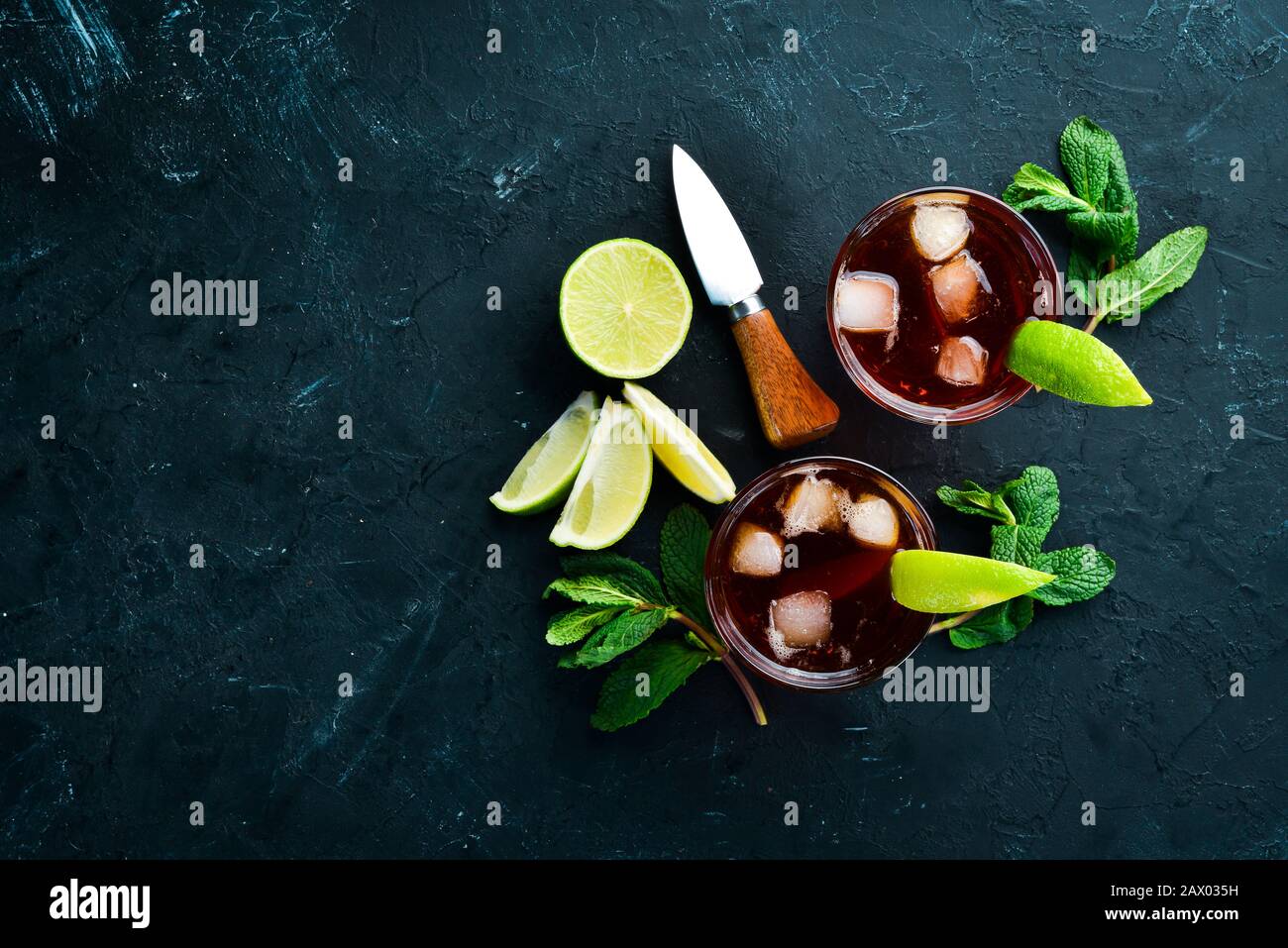 Bevande alcoliche Rum, lime e menta su sfondo di pietra nera. Vista dall'alto. Spazio libero per il testo. Foto Stock