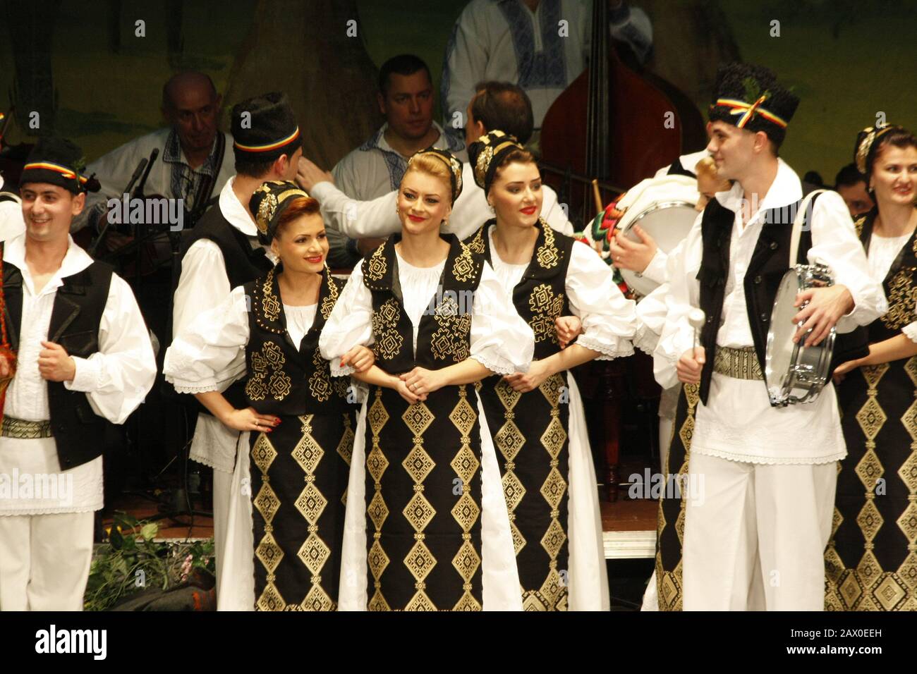 I ballerini professionisti del Banatul Folklore Ensemble tengono le mani in una danza tradizionale rumena indossando costumi tradizionali belli. Foto Stock