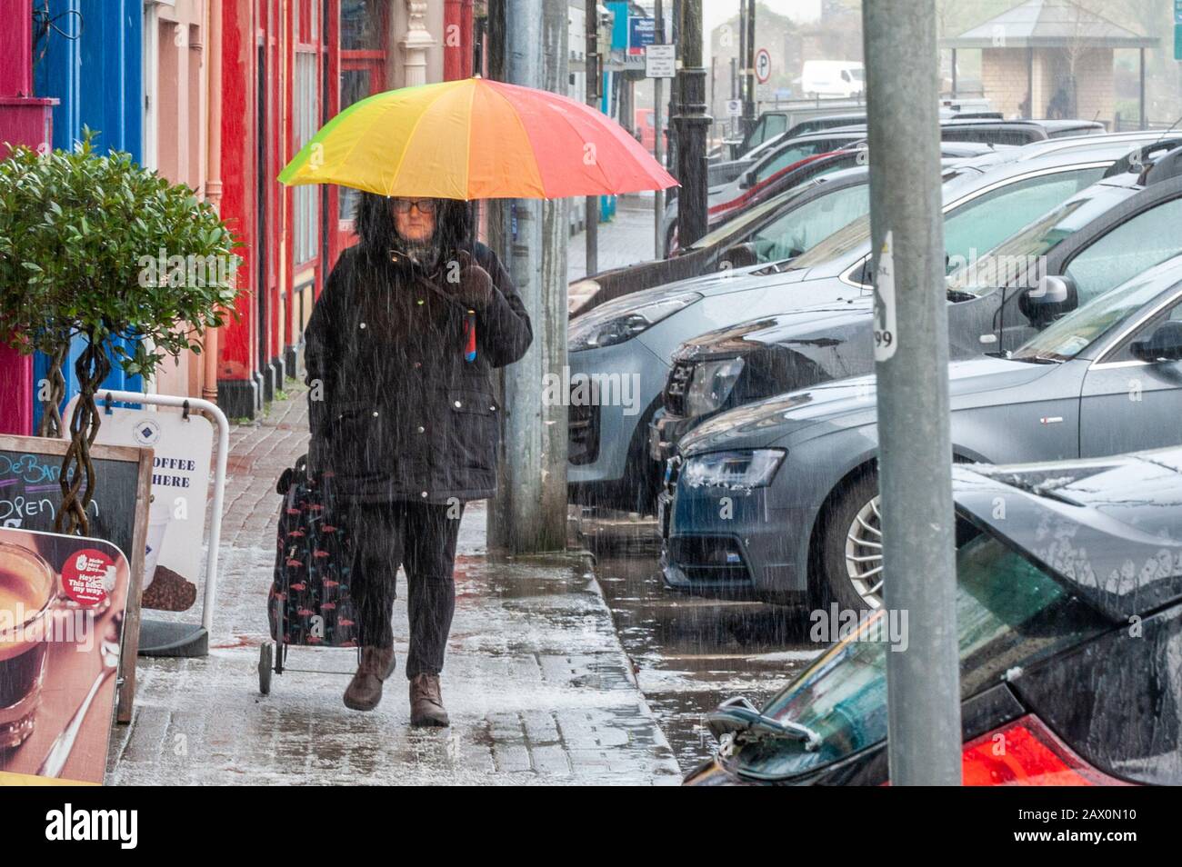 Bantry, West Cork, Irlanda. 10 Feb 2020. Una donna attraversa la città di Bantry nel tentativo di affrontare il tuono, il fulmine e la tempesta che hanno causato oggi un breve fallimento dell'approvvigionamento di energia elettrica della città. Credit: AG News/Alamy Live News Foto Stock