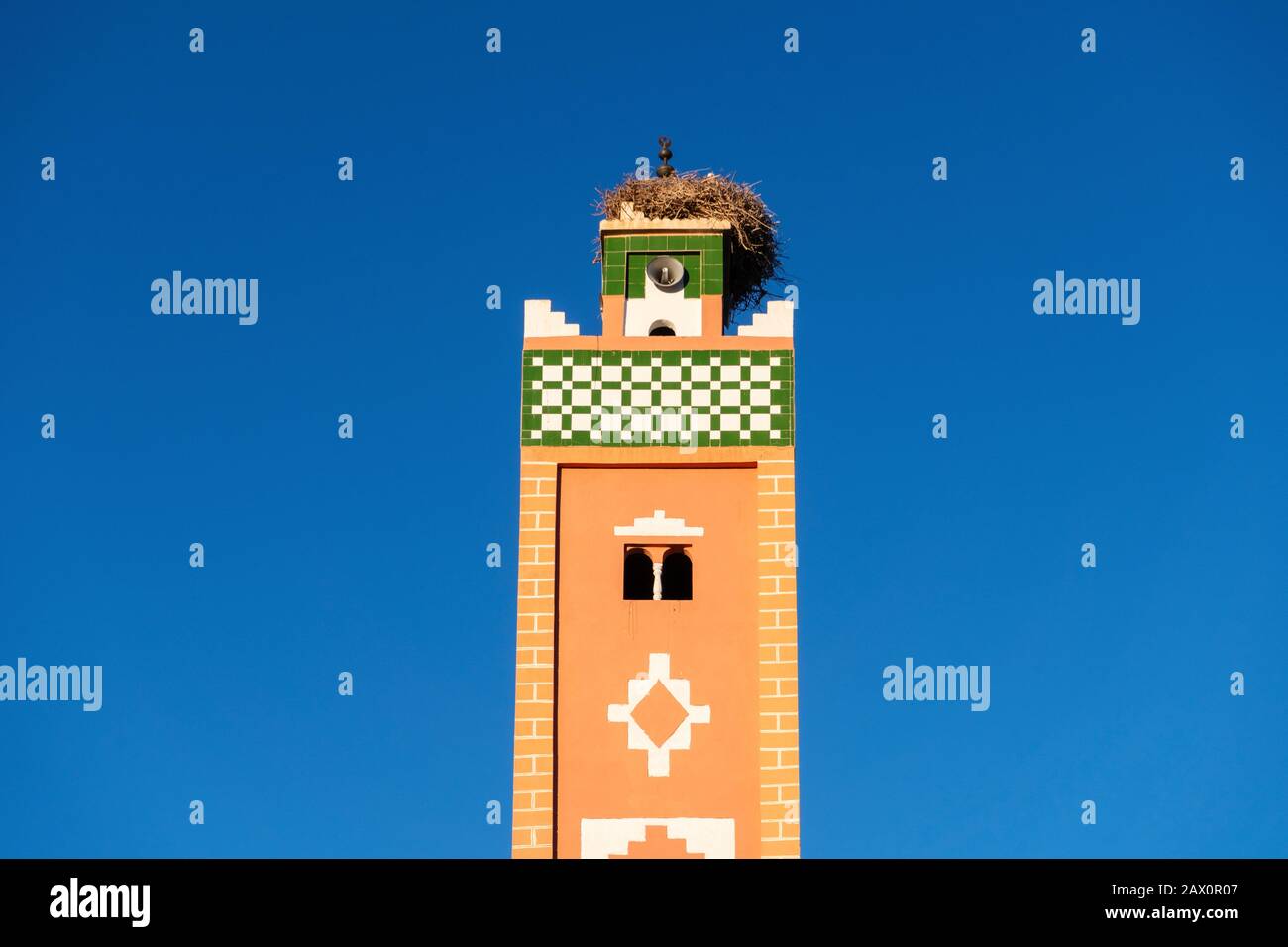 Minareto di moschea con nido di cicogne sulla cima in Ait ben Haddou, Marocco Foto Stock