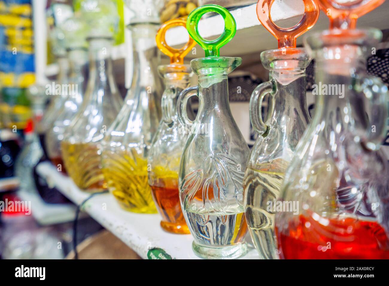 Varietà di oli in bottiglie di vetro esposte su scaffale nella medina di Marrakech, Marocco Foto Stock