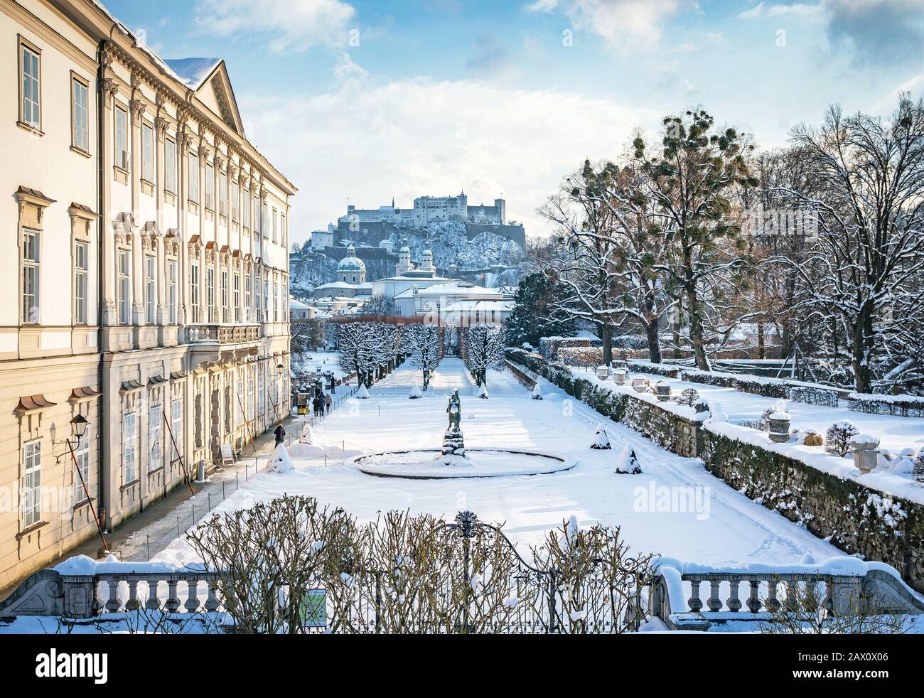 Vista classica dei famosi Giardini Mirabell nella storica città di Salisburgo con la Fortezza Hohensalzburg in una splendida serata invernale innevata, in Austria Foto Stock