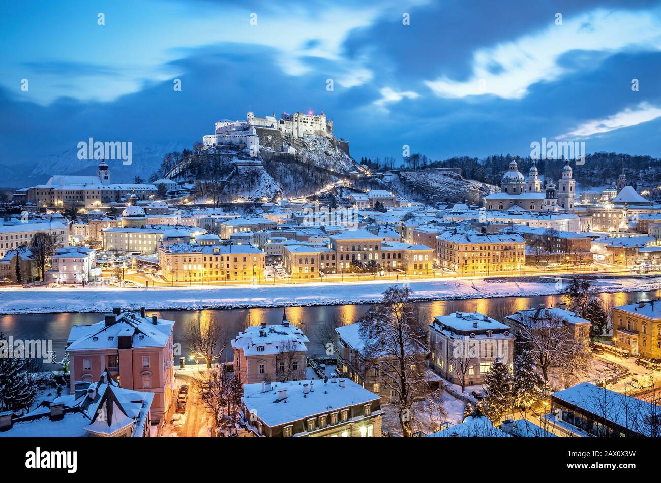 Classica veduta aerea della città storica di Salisburgo con il famoso Festung Hohensalzburg e il fiume Salzach illuminati in inverno, Salzburger Land, Austria Foto Stock