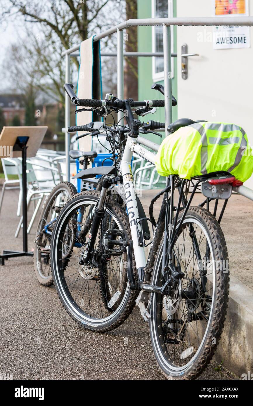 Vista laterale in primo piano della West Mercia Force polizia mountain bike, ciclo di polizia, caffè esterno a sinistra nel parco del Regno Unito. Polizia comunitaria per un vicinato più sicuro. Foto Stock