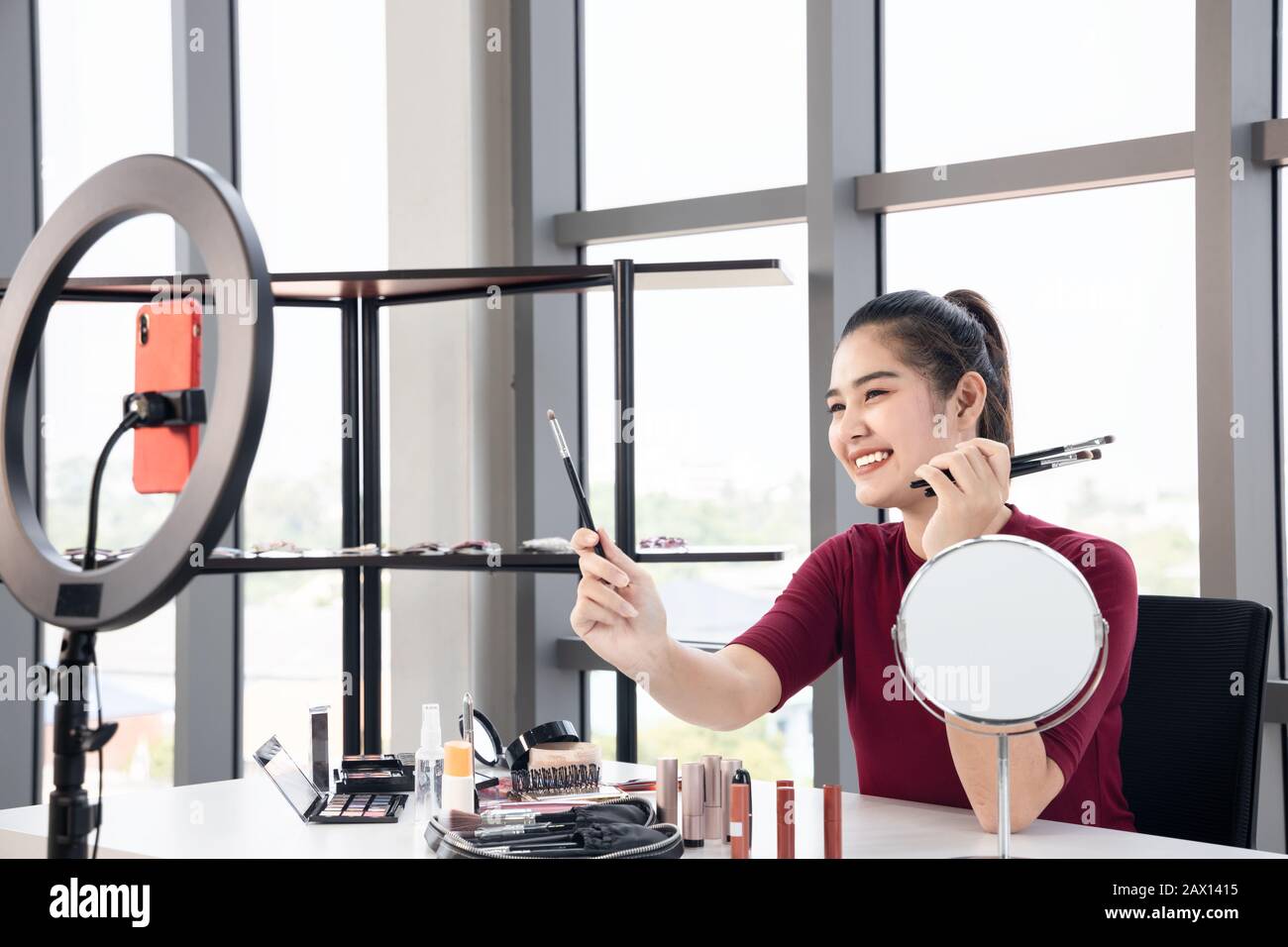Bella Asian influencer recensione vari tipi di cosmetici. Donna bellezza blogger presente sul suo make-up che usa ogni giorno. Foto Stock