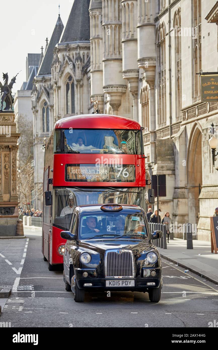 Autobus e Taxi a Londra a Strand con I Royal Courts of Justice sullo sfondo. Foto Stock