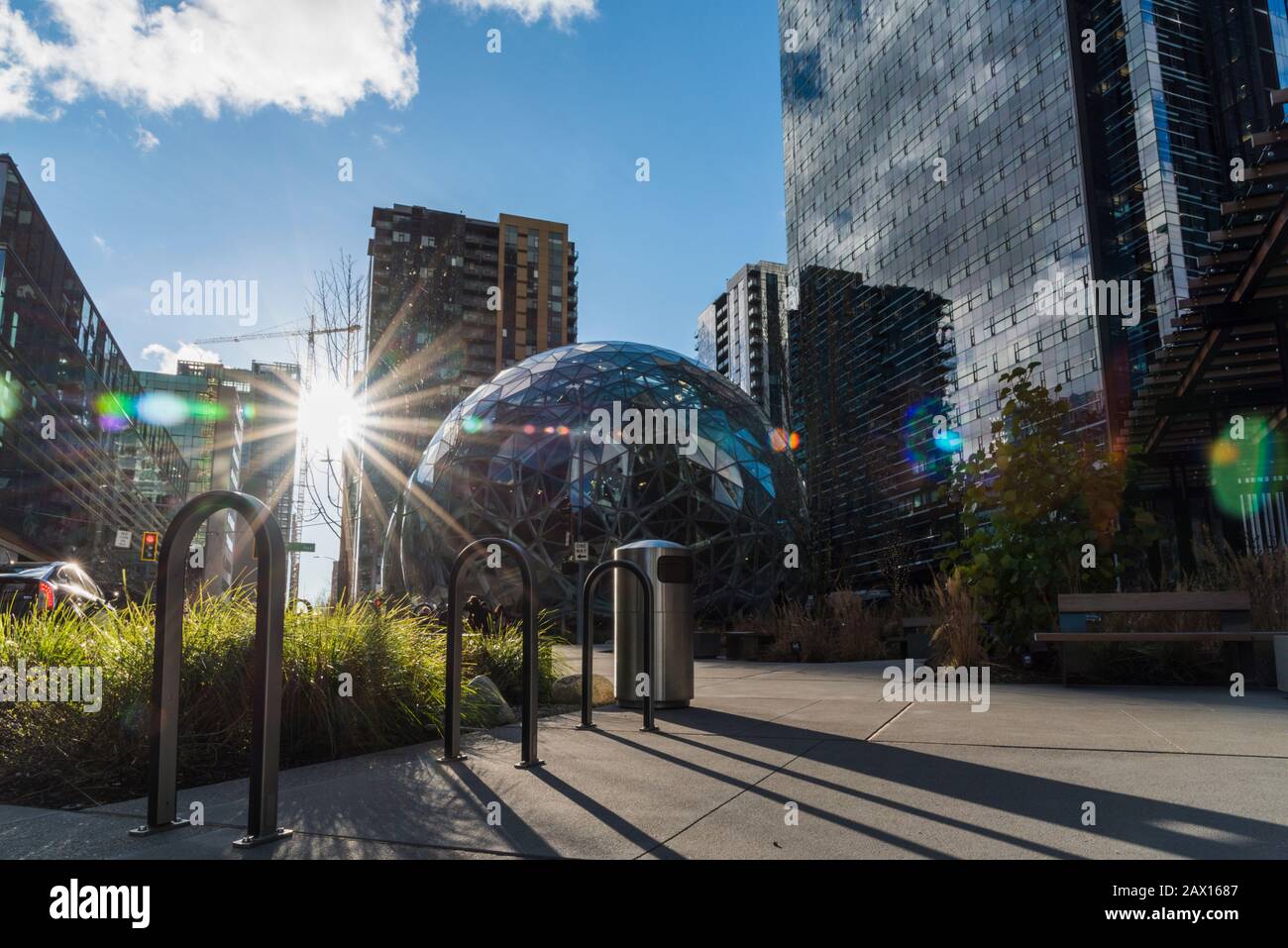 Portabici accanto alle Sfere della sede centrale del mondo di Amazon con il sole del tramonto del sole del tardo giorno del flare della lente. Foto Stock