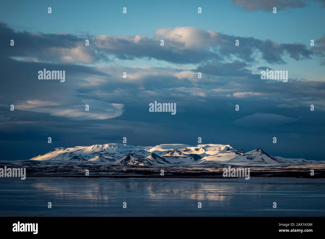 Montagne lungo un lago in Islanda con nuvole di alci Foto Stock