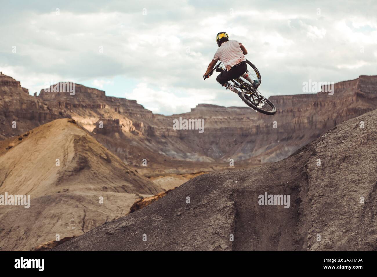 Tiro di atleta maschile che salta con MTB nel deserto Foto Stock
