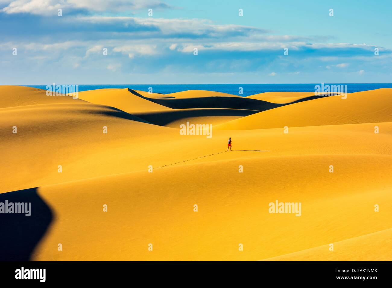 Persona irriconoscibile che fa jogging alle dune di sabbia di Maspalomas Gran Canaria Spagna Foto Stock