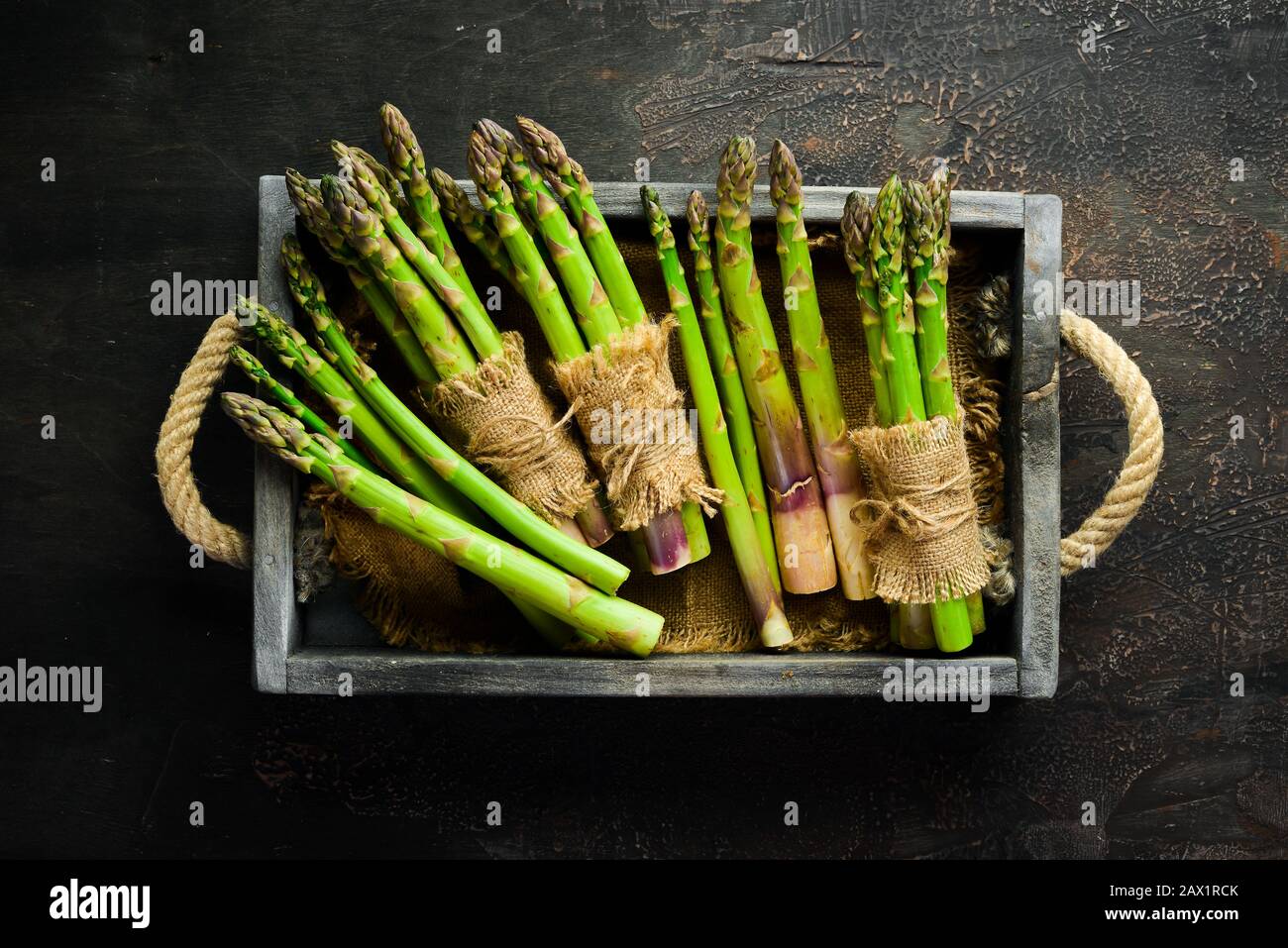 Asparagi freschi in una scatola di legno. Cibo sano. Vista dall'alto. Spazio libero per il testo. Foto Stock