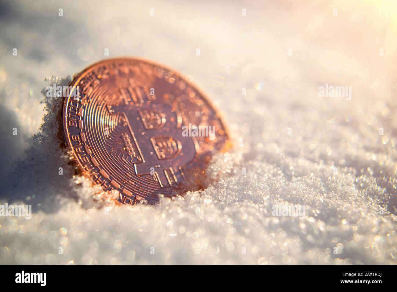 La moneta d'oro della criptovaluta Bitcoin sta gelando nella neve sotto il sole in attesa di sciogliersi e scongelare. Il prezzo rompe la zona di congelamento Foto Stock