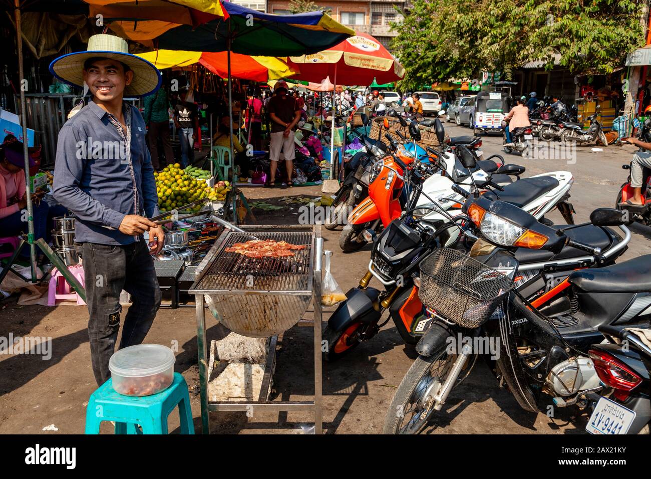 A Man Cooks Meat On Grill, Battambang, Cambogia. Foto Stock