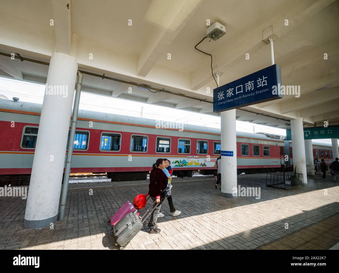 Passeggeri cinesi di sesso femminile con bagagli sulla piattaforma della stazione ferroviaria di Intercity Zhangjiakou South, provincia di Hebei, Cina Foto Stock