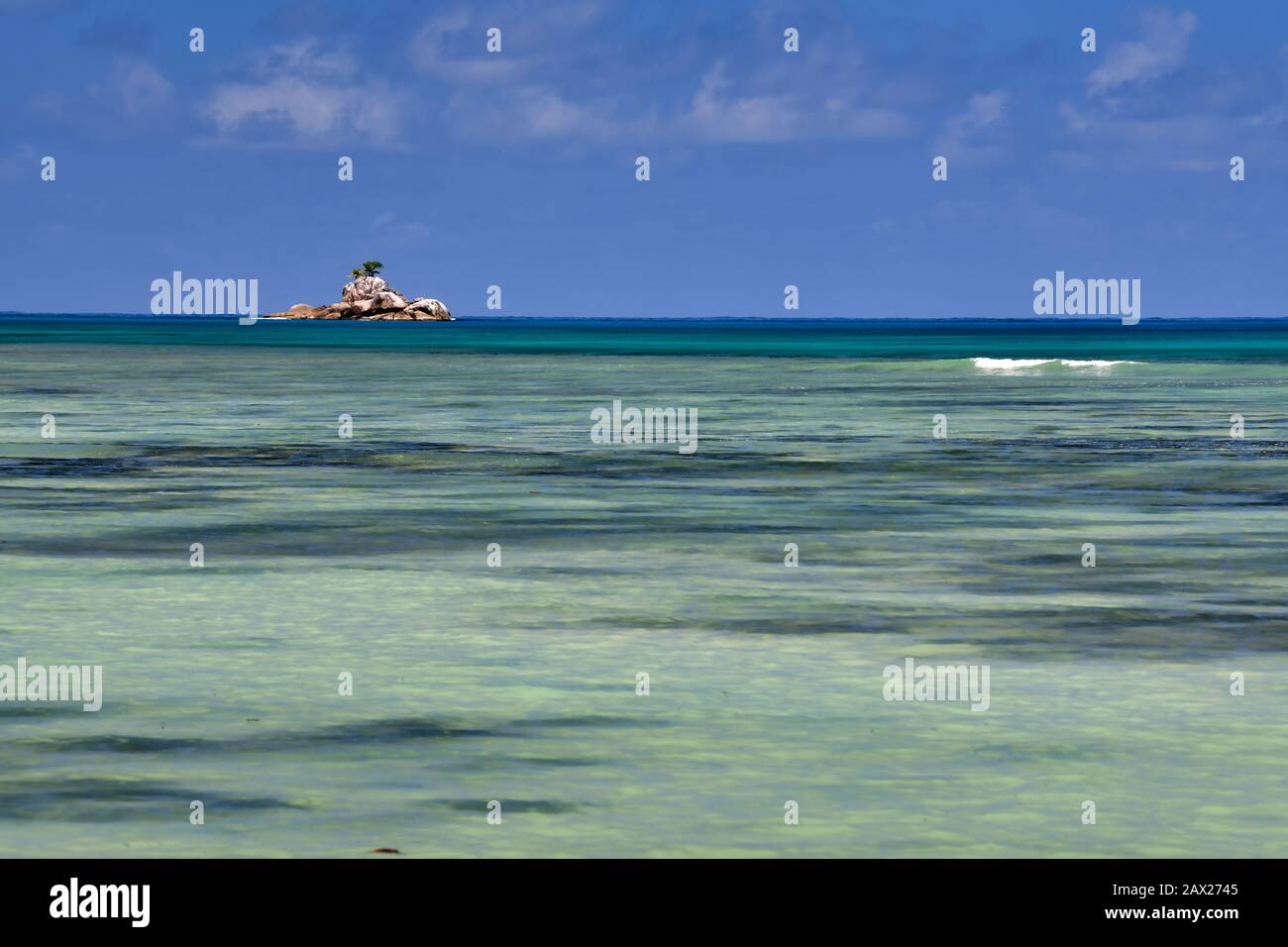 Onde oceaniche, acque turchesi e baby cielo blu. Anse A La Mouche, Isola Di Mahe, Seychelles. Foto Stock