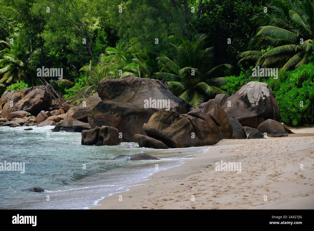 Onde dell'oceano e rocce di granito - Baie Lazare Beach, Mahe Island, Seychelles. Foto Stock