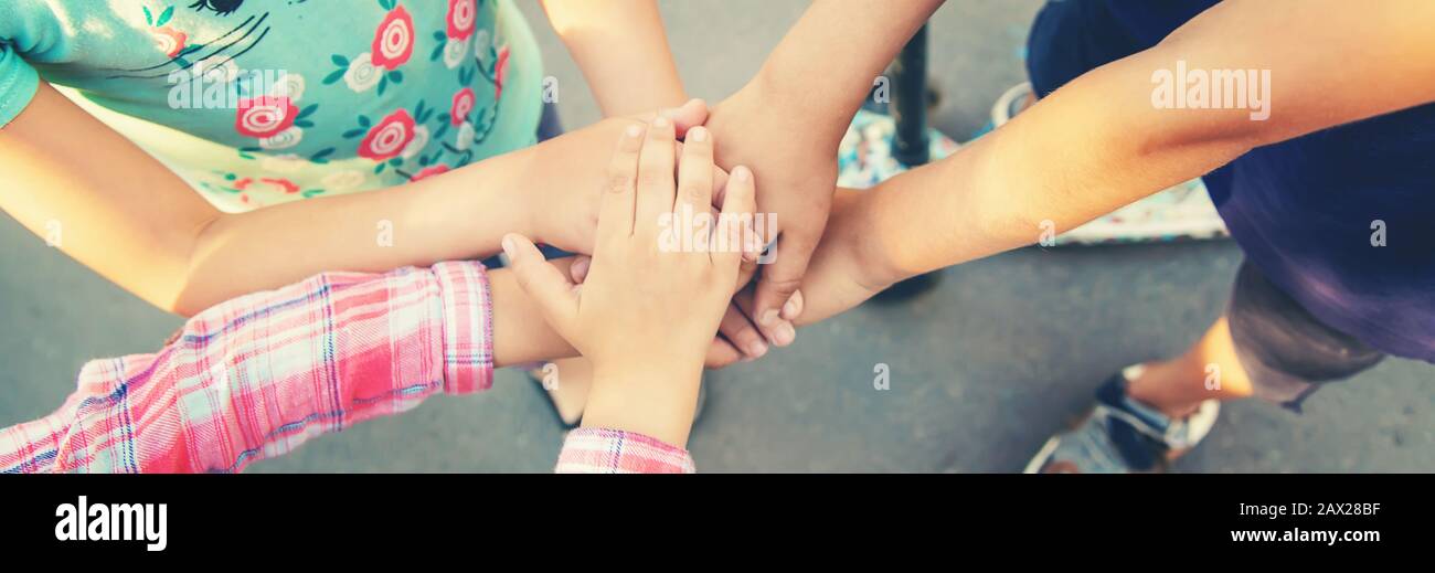 Mani di bambini, molti amici, giochi. Messa a fuoco selettiva estate Foto Stock