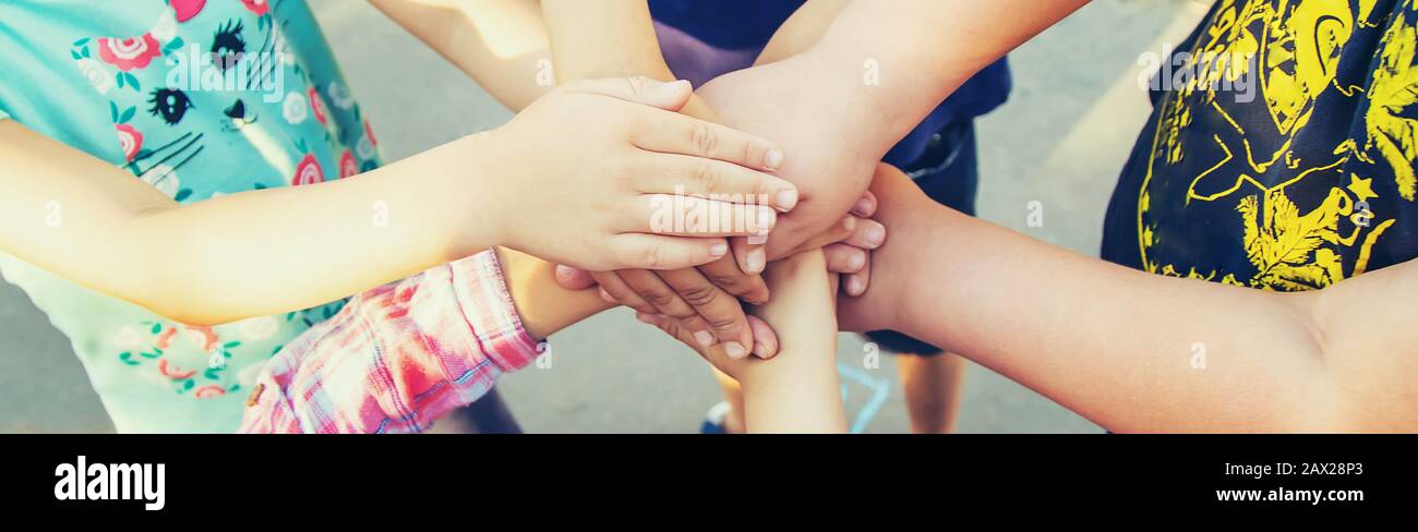 Mani di bambini, molti amici, giochi. Messa a fuoco selettiva estate Foto Stock