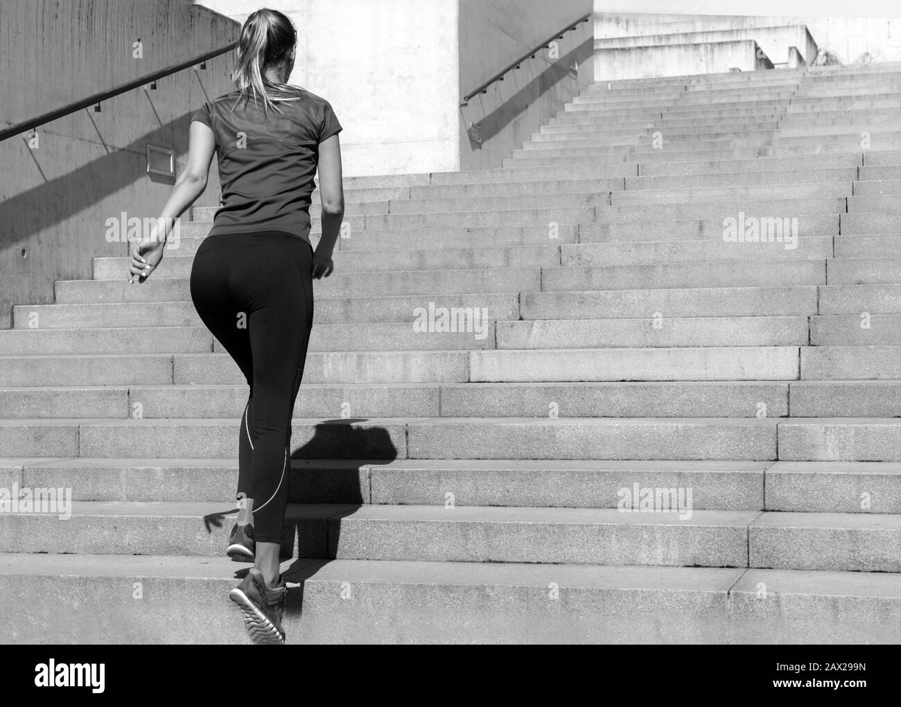 Giovane ragazza sportiva in una cima e leggings che pareggiare sulle scale. Bella donna sportiva. Concetto di sport e salute. Foto Stock