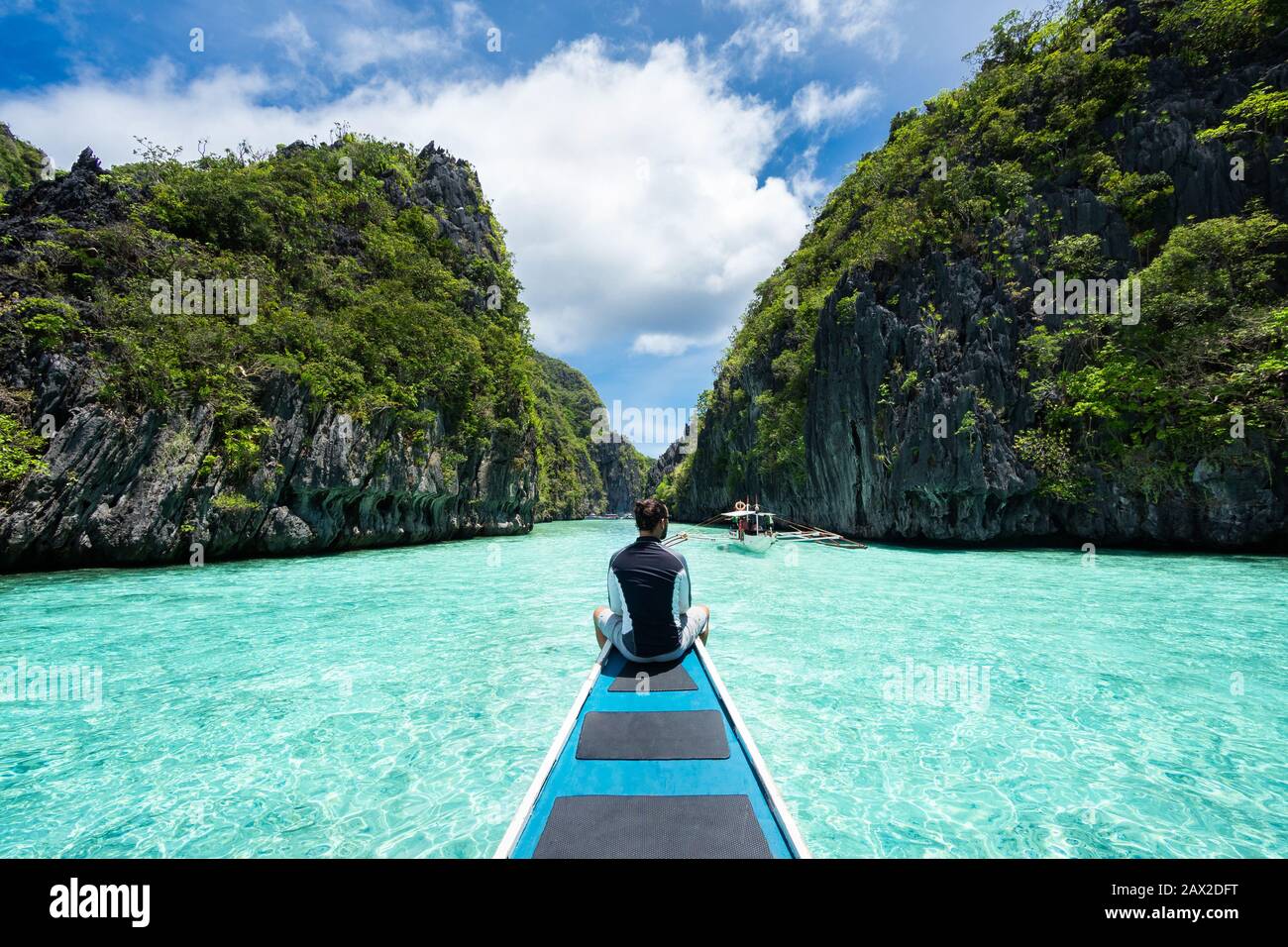 El Nido, Palawan, Filippine, viaggiatore seduto sul ponte della barca per esplorare le attrazioni naturali intorno a El Nido in una giornata di sole. Foto Stock