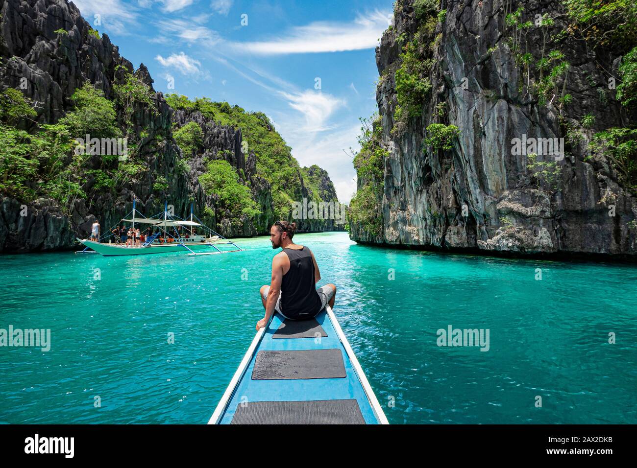 El Nido, Palawan, Filippine, viaggiatore seduto sul ponte della barca per esplorare le attrazioni naturali intorno a El Nido in una giornata di sole. Foto Stock