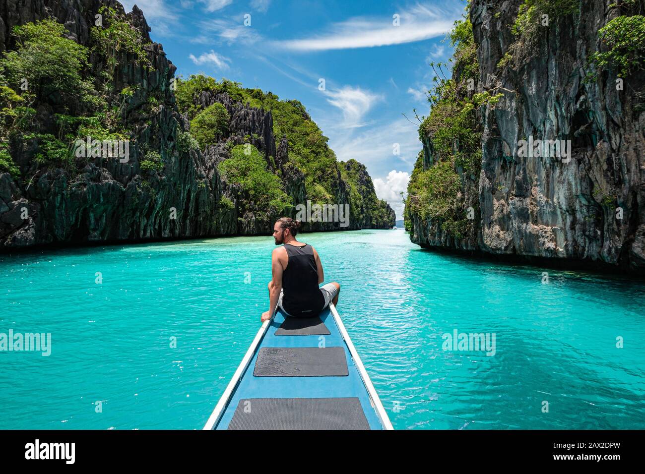 El Nido, Palawan, Filippine, viaggiatore seduto sul ponte della barca per esplorare le attrazioni naturali intorno a El Nido in una giornata di sole. Foto Stock