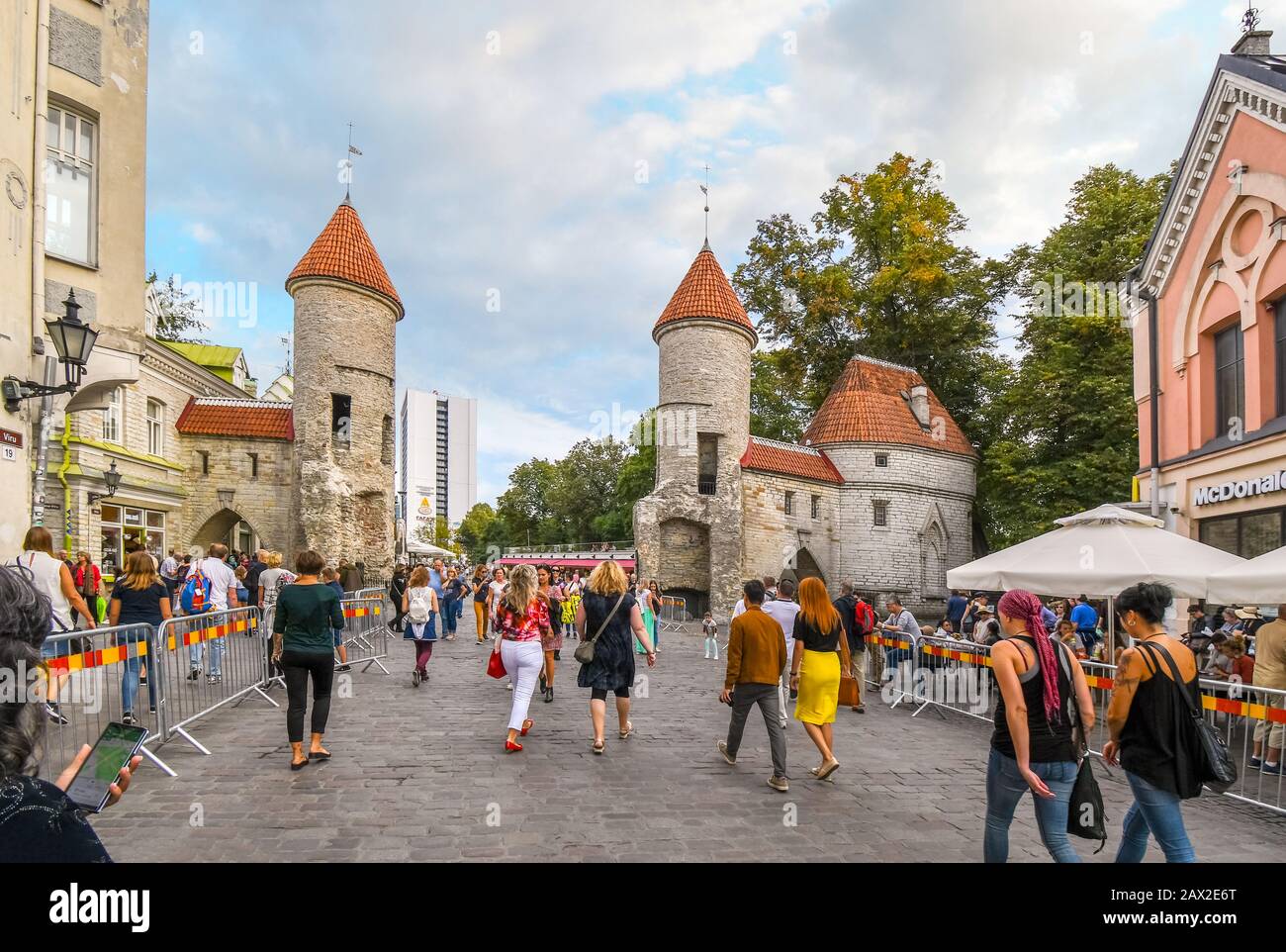I turisti lasciano la città vecchia medievale di Tallinn Estonia attraverso la pittoresca porta Viru. Foto Stock