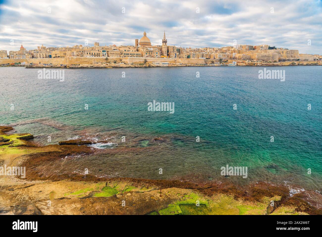 Valletta, lo skyline della città vecchia di Malta dalla città di Sliema sull'altro lato del porto di Marsans durante l'alba Foto Stock